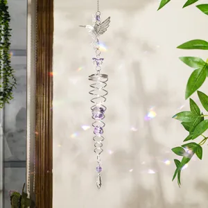 Detalle del atrapasol de cristal de colibrí con reflejos de prisma en la pared.
