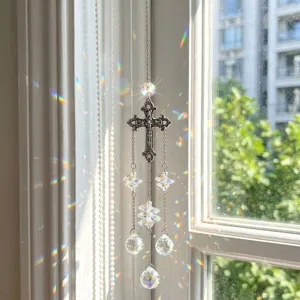 Dettaglio di acchiappasole in cristallo con croce argento e riflessi di luce arcobaleno