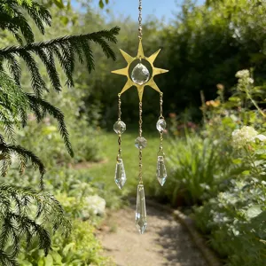 Dettaglio di un acchiappasole dorato con prismi in cristallo in un verde giardino