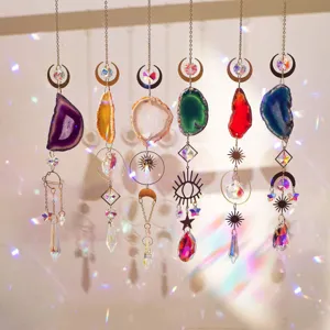 Row of colorful agate sun catchers creating rainbow light reflections on a wall.
