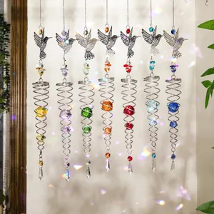 Primer plano de siete atrapasoles de cristal de colibrí que reflejan la luz del arco iris.