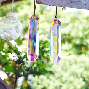 Dettaglio di prismi acchiappasole in cristallo cangiante appesi in un giardino soleggiato