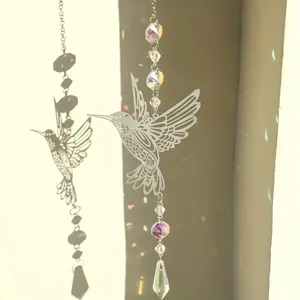 Detalle de atrapasueños de colibrí con cuentas de cristal junto a una ventana