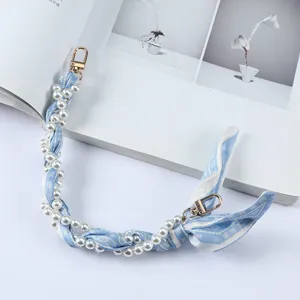 Detail van de elegante polsband voor telefoon van parels en blauwe zijden sjaal