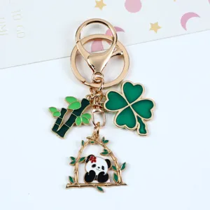 Close-up of a gold panda keychain with bamboo and green four-leaf clover charms