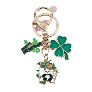 Cute cartoon panda keychain with bamboo and four-leaf clover charms on a gold ring holder