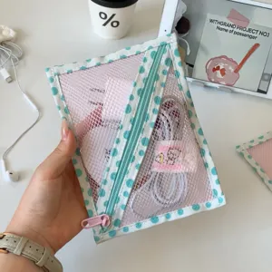 Detailopname van een halfdoorzichtige mesh-tas met stippen met kabels en een lader