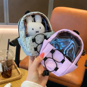 Detail view of polka dot mini backpack doll bags with transparent window and rabbit doll.