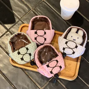 Miniature polka dot backpack doll bags in pastel colors arranged on a wooden tray