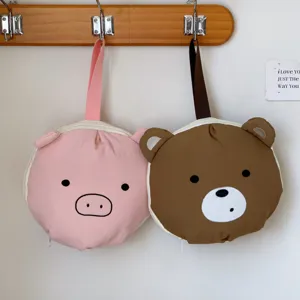 Lindas bolsas de viaje de oso y cerdo colgadas en un perchero para organizarlas.