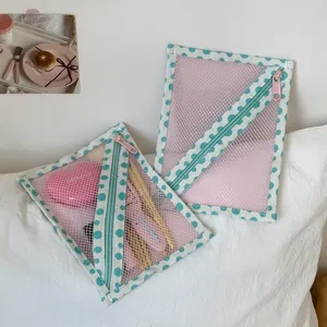 Detail van draagbare mesh opbergtas met polka dot patroon en roze ritssluiting