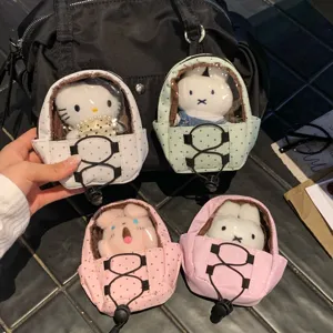 Detailed view of mini polka dot backpack keychains for doll display on a bag.