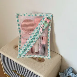 Detailweergave van de mintgroene stippen nettas met cosmetica artikelen erin