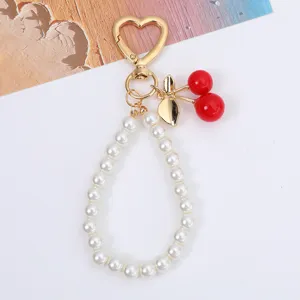 Sweet cherry and pearl bead keychain with golden heart-shaped clasp and leaf detail