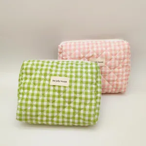 Macro view of lime green and pink quilted gingham makeup bags with diamond stitching.
