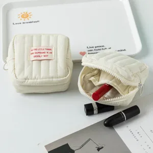Detailansicht der gesteppten Mini-Kosmetiktasche mit Innenfächern für Lippenstifte.