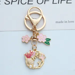 Vue détaillée d'un porte-clés thème marin avec fleurs de cerisier roses et étoile de mer