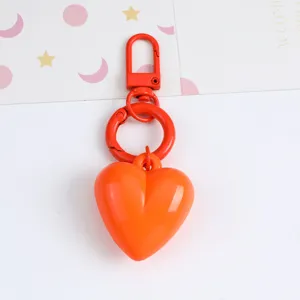 Macro view of a vibrant orange heart-shaped resin keychain with matching metal hardware clip