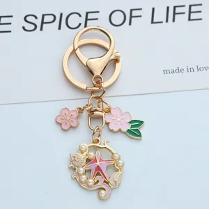 Gros plan macro d'un porte-clés émaillé avec des fleurs de cerisier et une étoile de mer