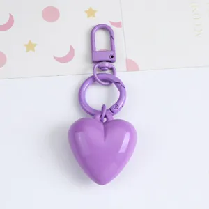 Close-up of a candy purple resin heart keychain pendant with a matching carabiner