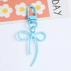 Close-up detail of a light blue alloy bow-knot keychain pendant for bags and DIY crafts