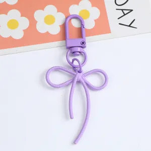 Detailed macro view of a stylish purple alloy bow keychain pendant for bags and accessories