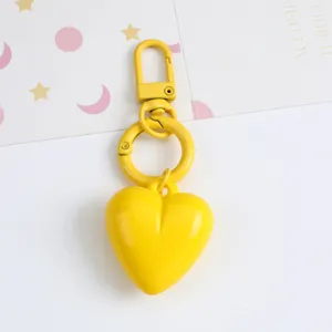 Close-up of a vibrant yellow candy-colored resin heart keychain with matching hardware.