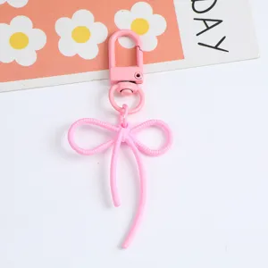 Close-up of pink alloy bow keychain with a secure lobster clasp.