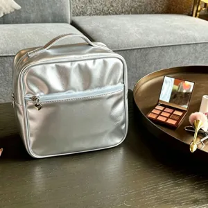 Professional silver metallic PU makeup organizer bag shown in a luxury lifestyle setting