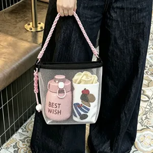 Detailed view of white mesh beach bag with pink braided handle and interior storage.