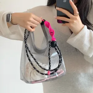 Asian model holding a grey mesh EVA waterproof beach bag with pink braided handle.