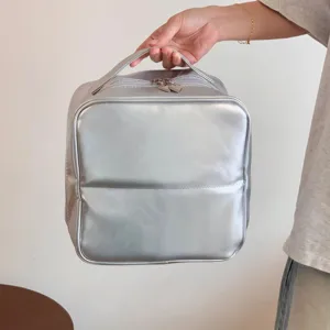 Silver PU leather makeup bag detail showing metallic texture and heart shaped zipper pulls