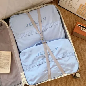 Detalle de bolsas organizadoras de viaje azul claro dentro de una maleta abierta