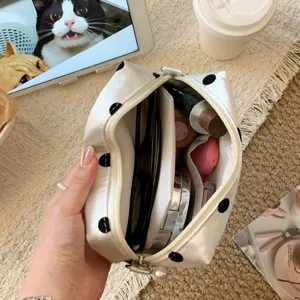 Detailed view showing the interior storage capacity of a white polka dot pouch