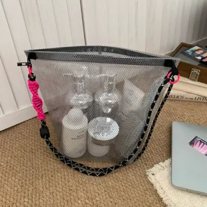 Detail shot of a grey mesh tote bag for travel showing capacity and interior bottles