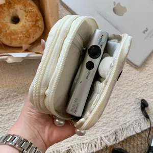 Interior detail of large capacity white polka dot pouch holding a small digital camera