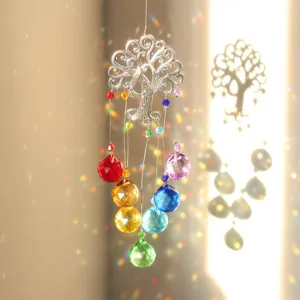 Rainbow crystal sun catcher pendant casting colorful light reflections on the wall.