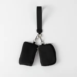 Primer plano de dos mini bolsas negras con cremallera sujetas a una muñequera