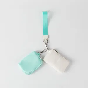 Primer plano de una muñequera de doble bolsa menta y blanco con herrajes metálicos.