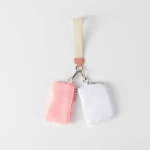 Vista detallada del bolso de muñeca portátil doble en rosa y blanco con correa de tela