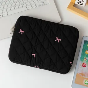 Close-up of quilted black laptop sleeve with cute pink bow embroidery details