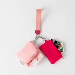 Detalle del mini monedero rosa con correa para la muñeca para guardar efectivo y tarjetas