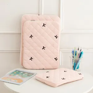 Pink quilted tablet sleeve with cute embroidered black bows and secure zipper closure detail