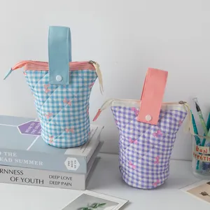 Vue détaillée de trousses à crayons matelassées à carreaux avec nœuds roses