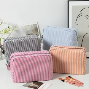 Seersucker striped makeup bags in various colors for travel organization.