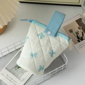 Gros plan détaillé du motif de nœud matelassé sur la trousse à crayons bleue et blanche