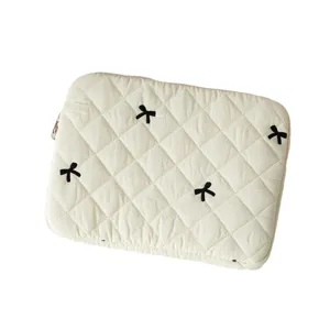 Minimalist cream white quilted laptop sleeve featuring cute black bow embroidery details
