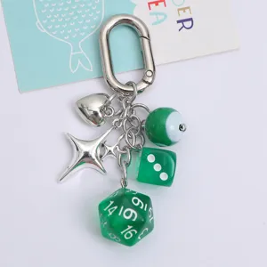 Detail view of lucky green dice and silver heart charms on an ins-style metal keychain