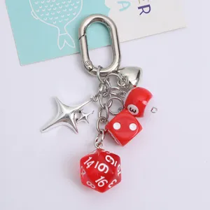 Detailed view of lucky red dice and billiard ball charms on a silver heart keychain