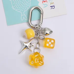 Macro view of creative keychain featuring yellow dice, silver heart and star charms
